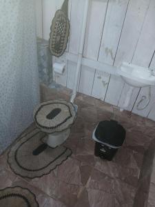a bathroom with a toilet and a sink at Hospedagem coqueiros in Soure