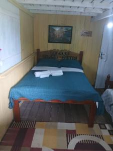 a bedroom with a bed with two towels on it at Hospedagem coqueiros in Soure