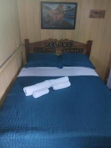a blue bed with two rolls of toilet paper on it at Hospedagem coqueiros in Soure