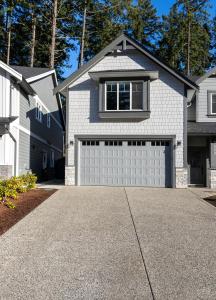 a house with a garage door in a driveway at Cozy Corner on Trumpeter in Colwood +10 photos