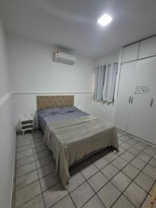 a bedroom with a bed in a white room at Casa com piscina in Petrolina +18 photos