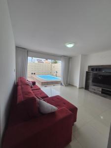 a living room with a red couch and a pool at Casa com piscina in Petrolina