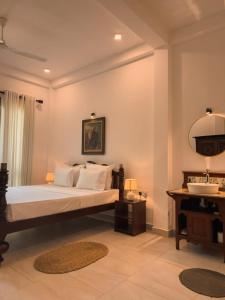 a bedroom with a bed with a sink and a mirror at Villa Sethoskai -100m to Beach in Ambalangoda