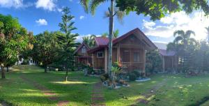 a house with a green yard in front of it at Valley Breeze Resort in Gabaldon