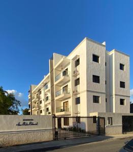 a white building with a fence in front of it at Apartamento San Pedro Colonial in San Pedro de Macorís