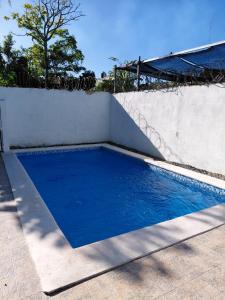 a blue swimming pool on a white wall at Apartamento San Pedro Colonial in San Pedro de Macorís