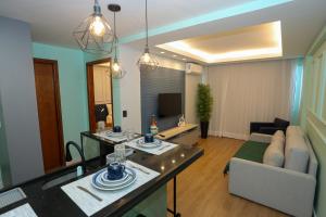 a living room with a couch and a table in a room at Flat Rosarinho - Confortável e Super Completo in Recife