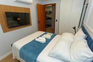 a bedroom with a bed with two towels on it at Flat Rosarinho - Confortável e Super Completo in Recife +66 photos