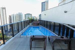a balcony with a swimming pool on top of a building at Flat Rosarinho - Confortável e Super Completo in Recife