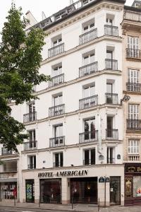 Un bâtiment blanc avec un panneau. dans l'établissement Hotel Americain, à Paris