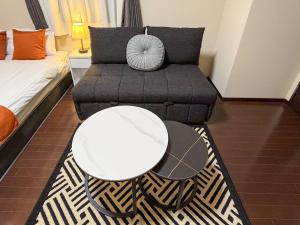a living room with a couch and a table at BALCOM STAY Hiroshima Otemachi in Hiroshima