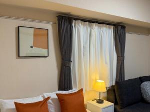 a living room with a couch and a window at BALCOM STAY Hiroshima Otemachi in Hiroshima +42 photos