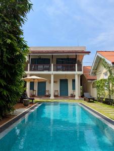 a villa with a swimming pool in front of a house at Villa Sethoskai -100m to Beach in Ambalangoda