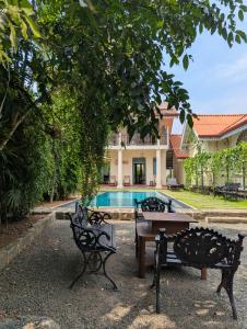 a table and chairs in front of a house with a pool at Villa Sethoskai -100m to Beach in Ambalangoda