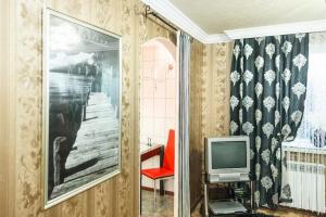 a living room with a television and a red chair at Apartment on Nezalezhnoy Ukrаiny near Intourist Hotel in Zaporozhye