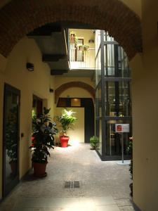 an empty hallway with potted plants in a building at Hotel Karol in Monza