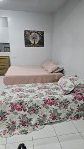 a bedroom with two beds and a painting on the wall at Estúdio Completo in Marabá