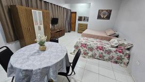 a room with a table and a bed and a couch at Estúdio Completo in Marabá +10 photos