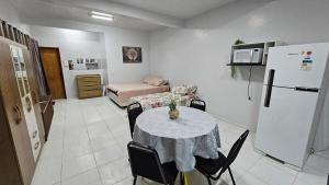 a living room with a table and a refrigerator at Estúdio Completo in Marabá