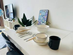a table with bowls and utensils on it at Pinnacle Pj by DeUrban in Petaling Jaya