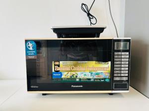 a microwave with a container on top of it at Pinnacle Pj by DeUrban in Petaling Jaya