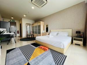 a bedroom with a large bed and a kitchen at Pinnacle Pj by DeUrban in Petaling Jaya