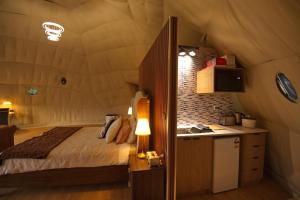a bedroom with a bed and a small kitchen at One life Glamping Tent in Rawson