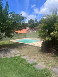 a swimming pool in the yard of a house at Granja Bagdá in Araras Petropolis