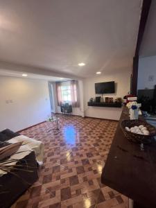 a living room with a table and a television at Granja Bagdá in Araras Petropolis