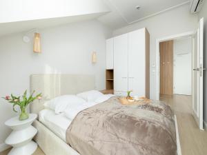 a white bedroom with a large bed and a bathroom at Comfortable apartment, right on the beach in Niechorze
