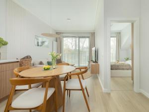 a kitchen and dining room with a table and chairs at Comfortable apartment, right on the beach in Niechorze