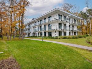 a large white building with a grass yard at Comfortable apartment, right on the beach in Niechorze