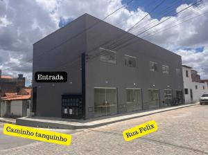 a black building with a sign on the side of it at Flats Temáticos - By Temporada Expert - Conforto e Climatizado in Feira de Santana