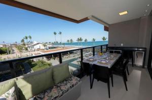 a dining room with a table and a view of the ocean at Resort Cais Eco Residence in Ipojuca +8 photos