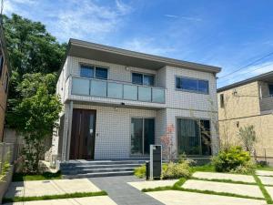 a white brick house with glass windows at Akikawa Koshi 1 プレミアム鉄骨 一棟貸切ヴィラ in Yuge