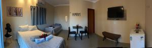 a bedroom with a bed and a tv and a couch at Margarida 01 in Monte das Gameleiras