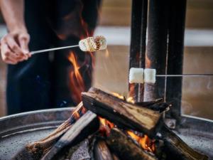 a person cooking food on a stick over a fire at Hakone Retreat Före in Hakone