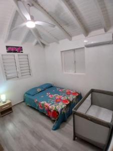 a bedroom with a bed and a ceiling fan at O paradis de Beauplan in Port-Louis