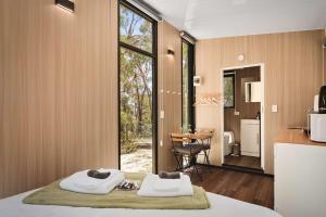 a bedroom with two towels sitting on a bed at Maroota Greens X by Tiny Away in Maroota