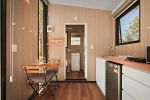 a kitchen with a table and chairs in a room at Maroota Greens X by Tiny Away in Maroota