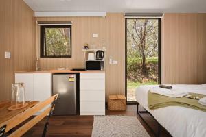a room with a kitchen and a bed and a kitchen at Maroota Greens X by Tiny Away in Maroota