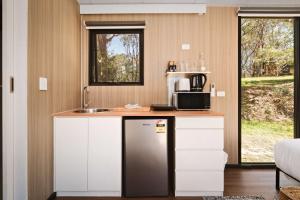 a kitchen with a counter with a sink and a refrigerator at Maroota Greens X by Tiny Away in Maroota +18 photos