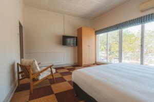 a bedroom with a bed and a chair and a window at Hotel Allen in Townsville +132 photos