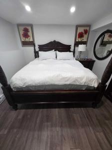 a bedroom with a large bed with white sheets at Peaceful escape in Ottawa