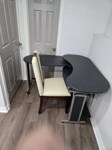 a black desk with a white chair and a table at Peaceful escape in Ottawa