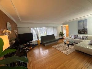 a living room with a couch and a tv at Charming Bright 3BR House - Upper Level Suite in Burnaby
