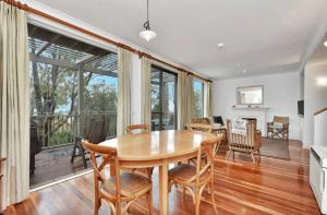an open living room with a wooden table and chairs at Villa Rose with Free Wine Tasting Included in Pokolbin