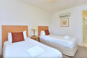 a hotel room with two beds and a window at Villa Rose with Free Wine Tasting Included in Pokolbin +13 photos