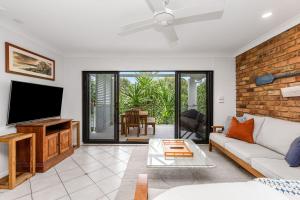 a living room with a couch and a flat screen tv at Atlantis 6 - 70 Lawson Street in Byron Bay