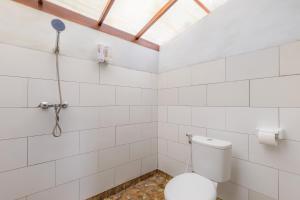 a bathroom with a toilet and a shower at La Rise Penida Cottage in Nusa Penida